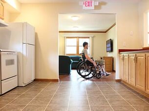 A person using a wheelchair inside an accessible kitchen.