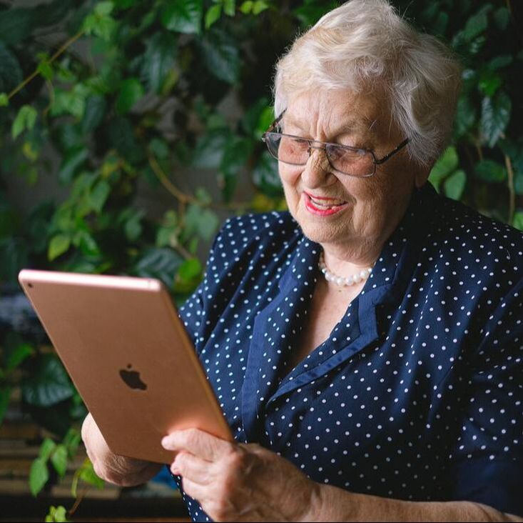 An photo of an elderly person using a tablet